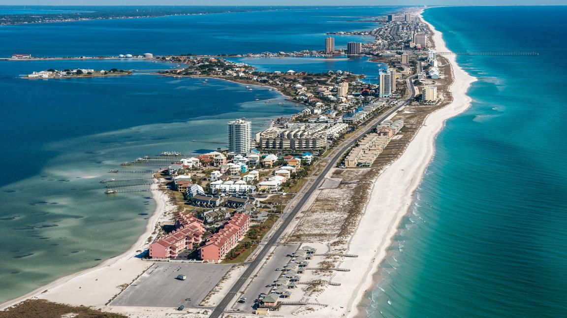 Aerial shot of Pensacola Beach with buildings and ocean view.