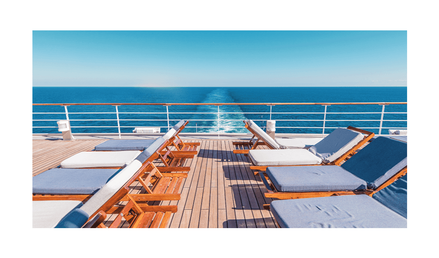 Deck of cruise ship with several lounge chairs against an ocean background.