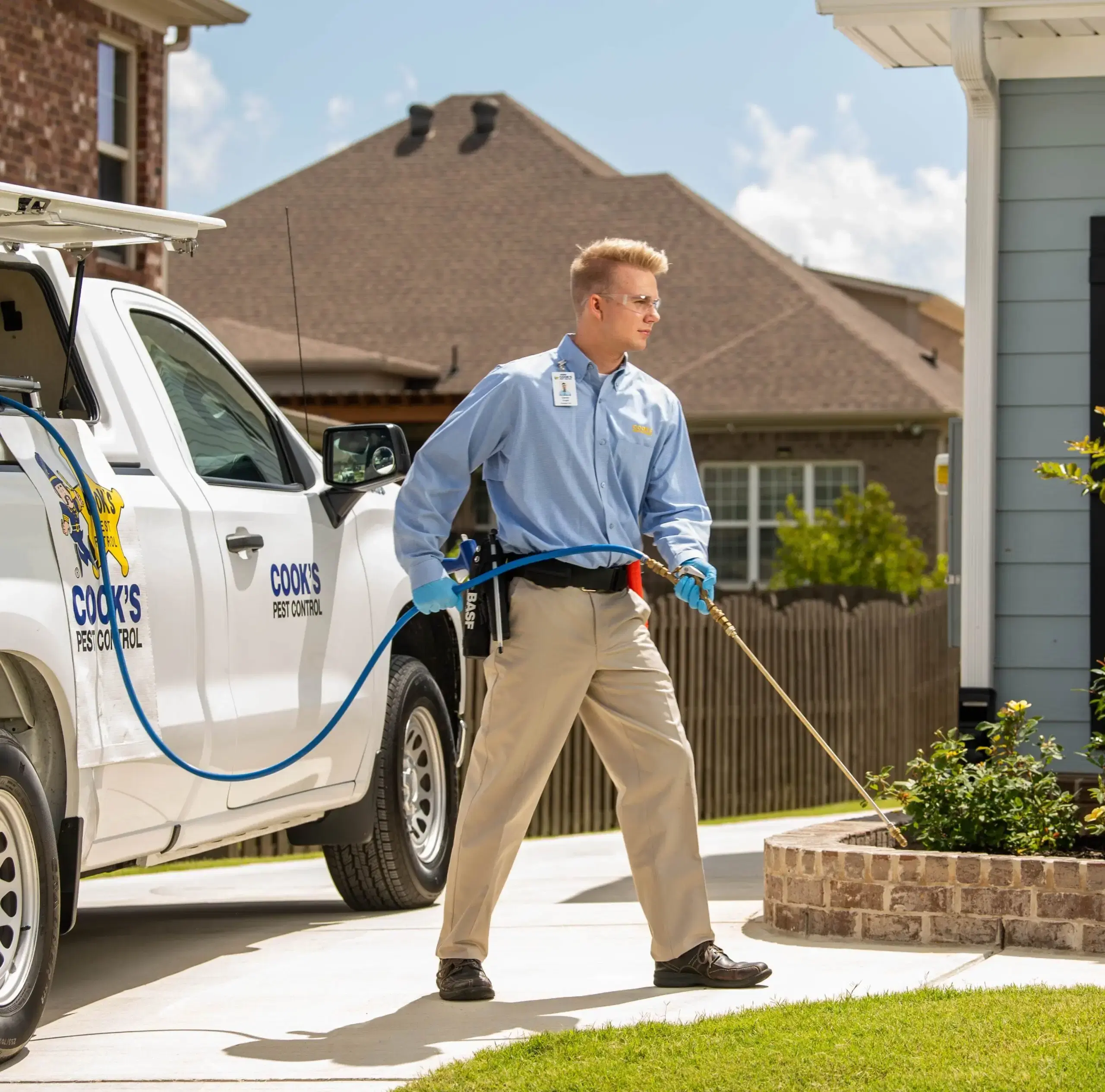 cooks pest employee in a residential yard performing mosquito control services